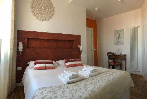 a bedroom with a large bed with towels on it at B&B Dimor'à in Pitigliano