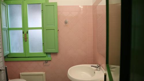 a bathroom with a sink and a green cabinet at Castelletto Verde in Bari Sardo