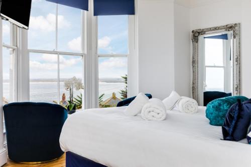 sypialnia z dużym białym łóżkiem i dużymi oknami w obiekcie Orla-Mo Victorian Captains House,St Ives,Cornwall,Sleeps10-15,Parking4cars,Refurb2022 w St Ives