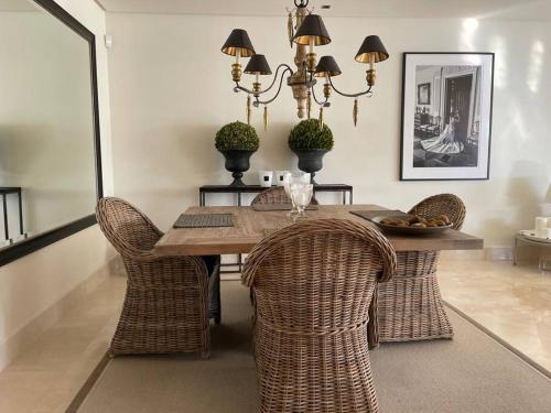 jadalnia ze stołem i wiklinowymi krzesłami w obiekcie Luxurious and light 3 bedroom penthouse w mieście Estepona