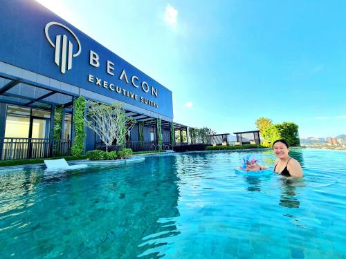 una mujer nadando en una piscina en un hotel en Beacon Executive Suites - Penang en George Town