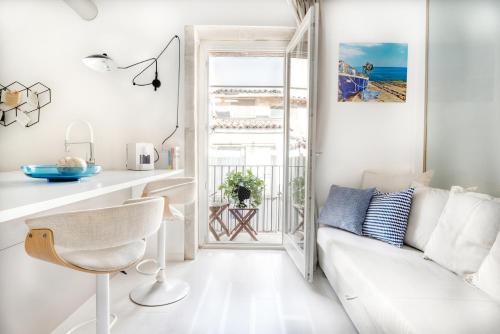 a living room with a white couch and a view of the ocean at Stay In Ortigia in Siracusa