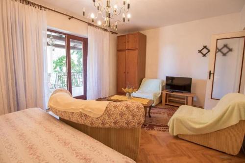 a living room with two beds and a television at Apartments Luka in Mali Lošinj