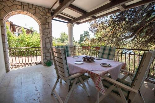 a table and chairs on a patio with an archway at Apartments Luka in Mali Lošinj