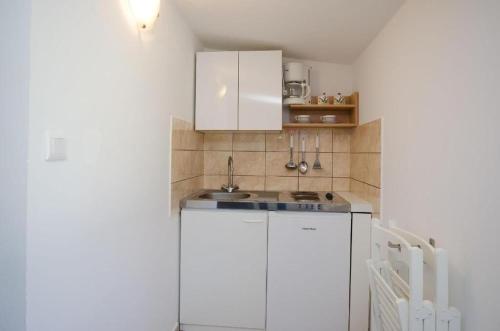 een kleine keuken met witte kasten en een wastafel bij Apartments Ivan Marina in Krk