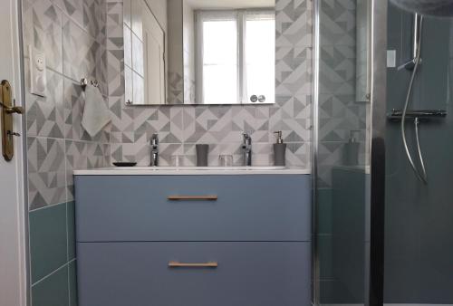 La salle de bains est pourvue d'un lavabo et d'un miroir. dans l'établissement La Maison De La Fontaine, Le Beny Bocage, à Le Bény-Bocage