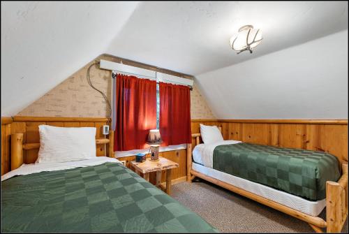 a attic bedroom with two beds and a window at Brundage Bungalows in McCall