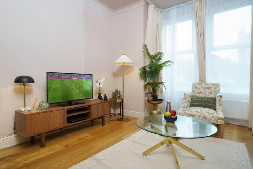 a living room with a television and a coffee table at Gorgeous apartment Wood Green Palmers Green in Palmers Green