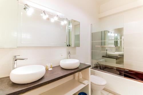 une salle de bain blanche avec un lavabo et des toilettes dans l'établissement SELECT'SO HOME - Villa Marytime - Piscine & Vue mer - Services Hôteliers, à Bormes-les-Mimosas