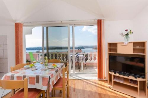 jadalnia ze stołem i widokiem na ocean w obiekcie Apartments Krunoslav w mieście Punat