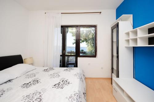 a bedroom with a bed and a window at Apartments Petra in Crikvenica