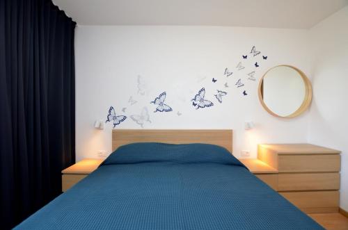 a bedroom with a bed with butterflies on the wall at Apartments Marija in Cres