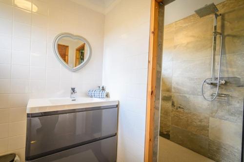 a bathroom with a sink and a shower at Red Squirrel log cabin with hot tub in Keith