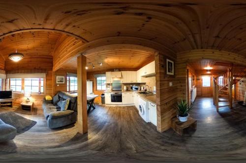 una gran sala de estar y cocina en una cabaña de madera en Red Squirrel log cabin with hot tub, en Keith