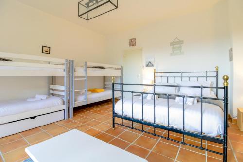 Cette chambre dispose de carrelage et de trois lits superposés. dans l'établissement SELECT'SO HOME - Villa Marytime - Piscine & Vue mer - Services Hôteliers, à Bormes-les-Mimosas