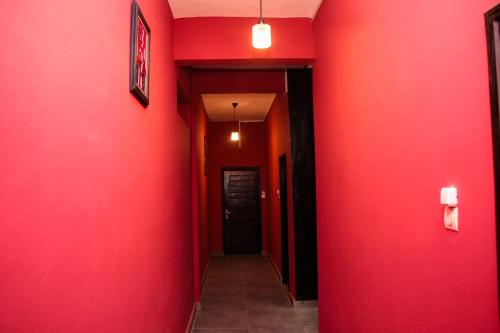einen Flur mit roten Wänden und einer roten Wand in der Unterkunft RESIDENCES AMADIRA in Parakou