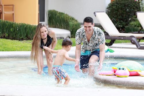 a man and a woman and a child playing in a pool at Casa Francisco in Cuernavaca