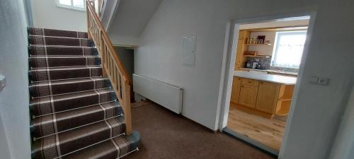 a hallway with a staircase leading to a kitchen with a sink at Chalupa Bílá stopa - celá chalupa pro jednu partu in Stará Ves