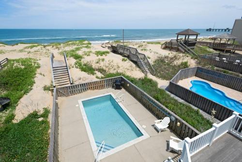 an overhead view of a swimming pool and the beach at Hidden Treasure - Nags Head MP 16, Oceanfront, Private Beach Access, Pool, Hot Tub, Pool Table, Pets OK in Nags Head