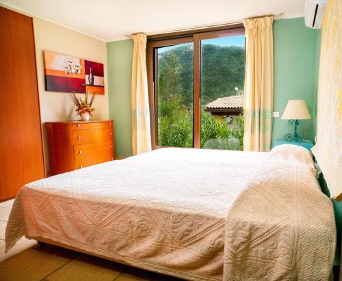 ドームス・デ・マリーアにあるCase Vacanza Bithiaのベッドルーム1室(ベッド1台、大きな窓付)