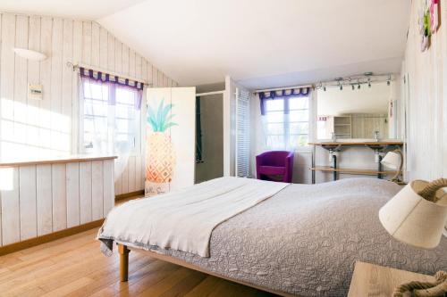 una camera con un grande letto e finestre di Acacias belle maison avec Piscine chauffée, Spa et Sauna a Rivedoux-Plage