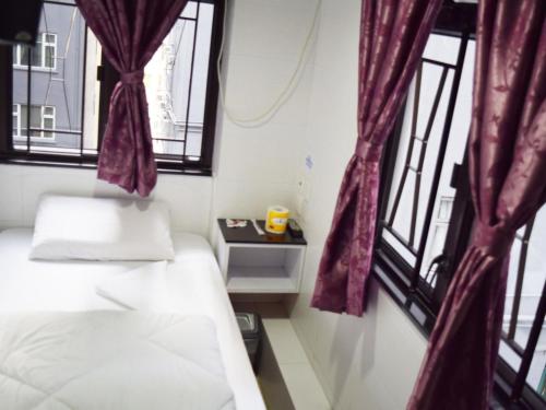 a small room with two beds and a window at Om Guest House in Hong Kong