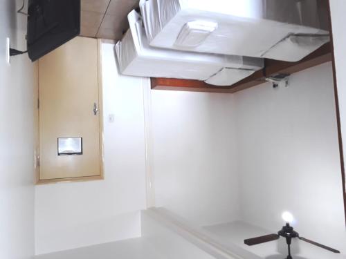 a ceiling fan in a room with a white wall at Minas Palace Hotel in Passos