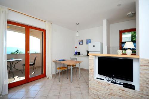 a living room with a flat screen tv and a table at Apartment Andreas in Ravni