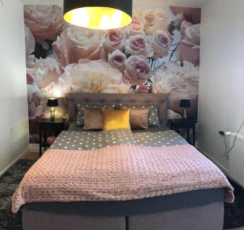 a bedroom with a bed with a wall of roses at Luma Exclusive in Osijek