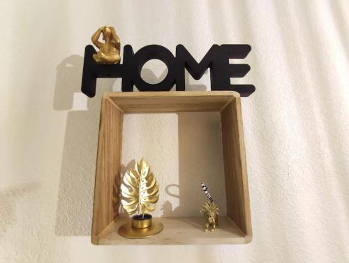 a wooden picture frame with a plant and the word home at Le Ouistiti - 50 m de la Gare - Parking Privé in Tours