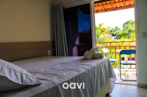 1 dormitorio con 1 cama y balcón con vistas. en Qavi - Apartamento no Centro de Pipa #Solar216, en Pipa