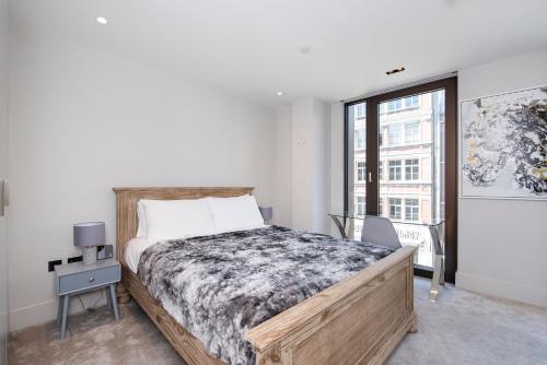 ein Schlafzimmer mit einem großen Bett und einem Fenster in der Unterkunft New Build-Air Con-2 Bedroom-Two Bathrooms Apt 4 in London