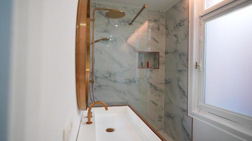 a bathroom with a shower and a tub with a sink at Hotel de Maître de Vaughan in Brussels