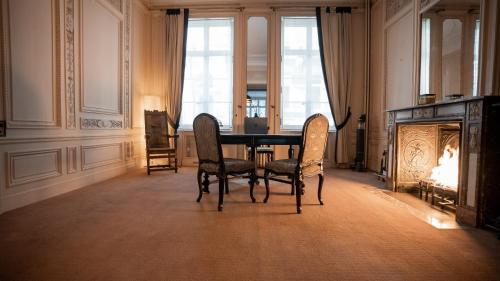 a dining room with a table and chairs and a fireplace at Hotel de Maître de Vaughan in Brussels