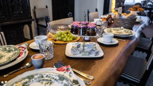 einem Holztisch mit Teller mit Lebensmitteln darauf in der Unterkunft Hotel de Maître de Vaughan in Brüssel