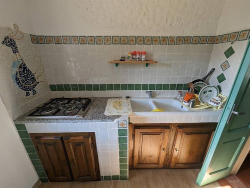 una piccola cucina con lavandino e piano cottura di (P3347) Cottage familiare Sant'Agostino ad Abbasanta
