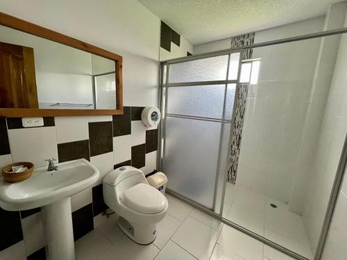 ein Bad mit einem WC, einem Waschbecken und einer Dusche in der Unterkunft Hostal Alpachaca - New Quito Airport in Tababela