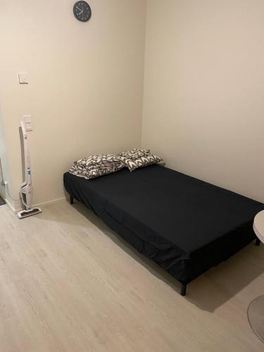 a bedroom with a black bed in a room at Ihana huoneisto juna aseman vieressä. in Vantaa