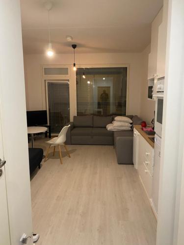 a living room with a couch and a kitchen at Ihana huoneisto juna aseman vieressä. in Vantaa