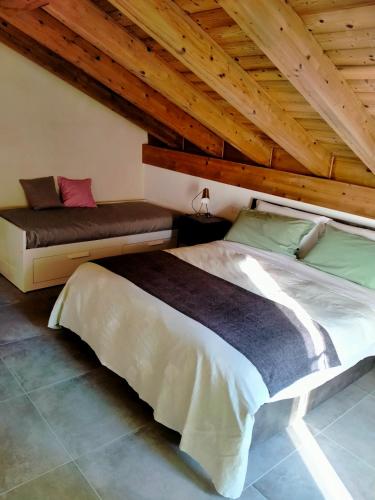 a bedroom with a bed and a wooden ceiling at Cozy Home Maison Cascina Amélie in Abbadia Lariana