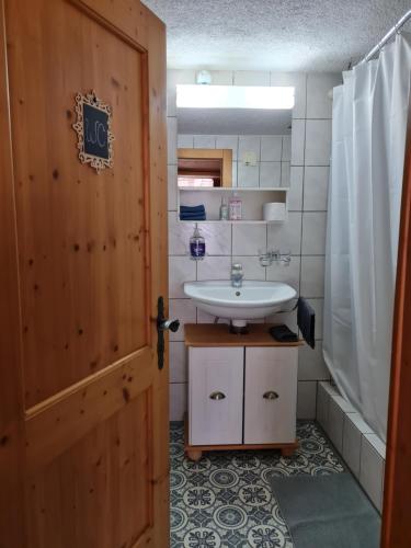 a bathroom with a white sink and a door at Chalet Ferreira in Weite