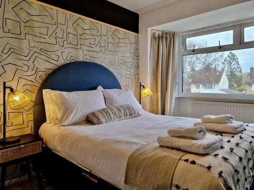 um quarto com uma cama grande e toalhas em Tranquil Rentals - Large 4 BDR Home, 3 Bathrooms, Free Parking, Monthly Discounts em Oxford
