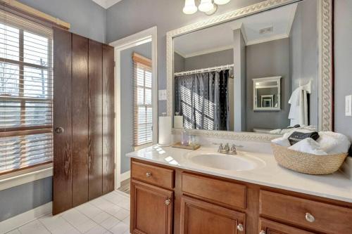 a bathroom with a sink and a large mirror at Luxury home with outdoor patio and game room in Memphis