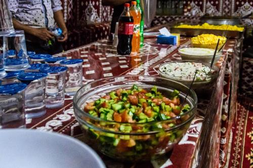 einen Tisch mit einer Schüssel Essen auf einem Tisch in der Unterkunft Wadi Rum stael Luxury Camp in Wadi Rum
