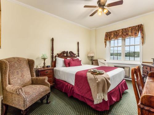 a bedroom with a bed and a chair and a window at Lafayette Hotel Marietta in Marietta