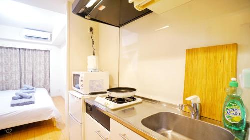 a kitchen with a sink and a stove in a room at TOKYO EXPERT SHINJUKU in Tokyo