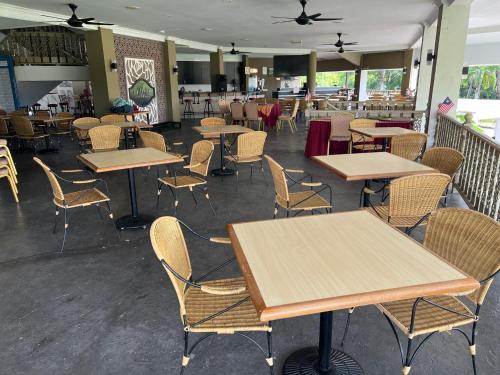ein Speisesaal mit Tischen und Stühlen in einem Restaurant in der Unterkunft Kuala Terengganu Golf Resort by Ancasa Hotels & Resorts in Kuala Terengganu