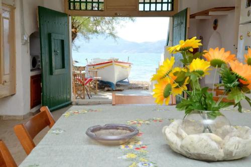 a table with a vase of flowers on top of it at Milos Apartments Kardapis Ground Floor in Klima