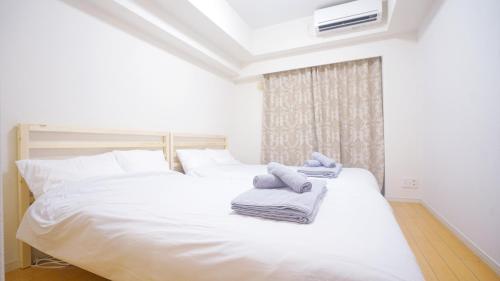 東京的住宿－TOKYO EXPERT SHINJUKU，一间卧室配有两张带毛巾的床