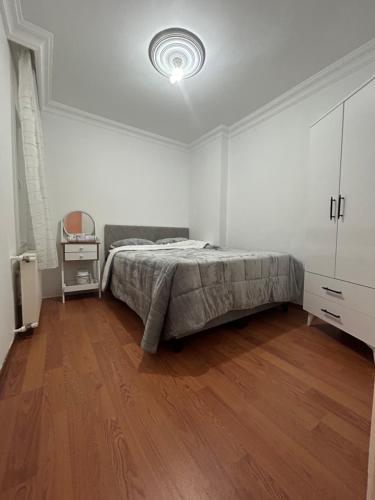 um quarto branco com uma cama e piso em madeira em noray1 em Istambul